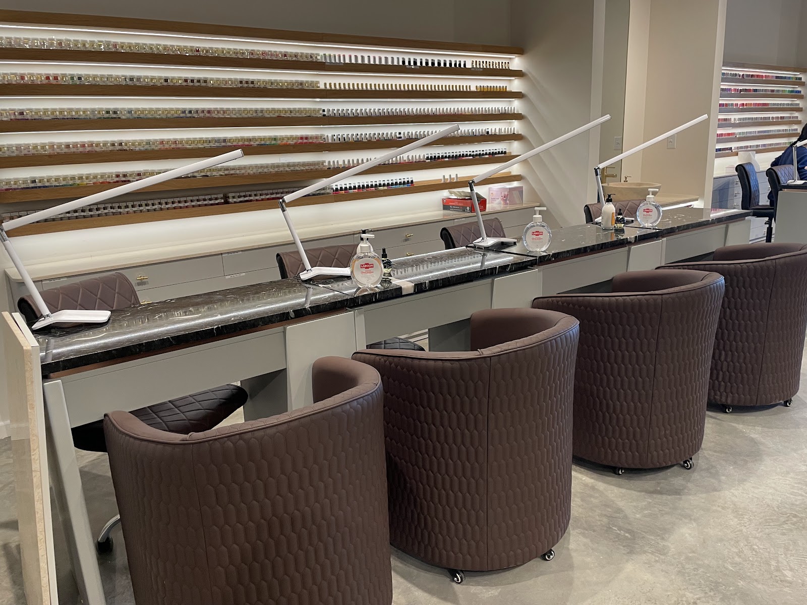 Manicure stations and polish wall at VSL Nail Spa Lone Oak