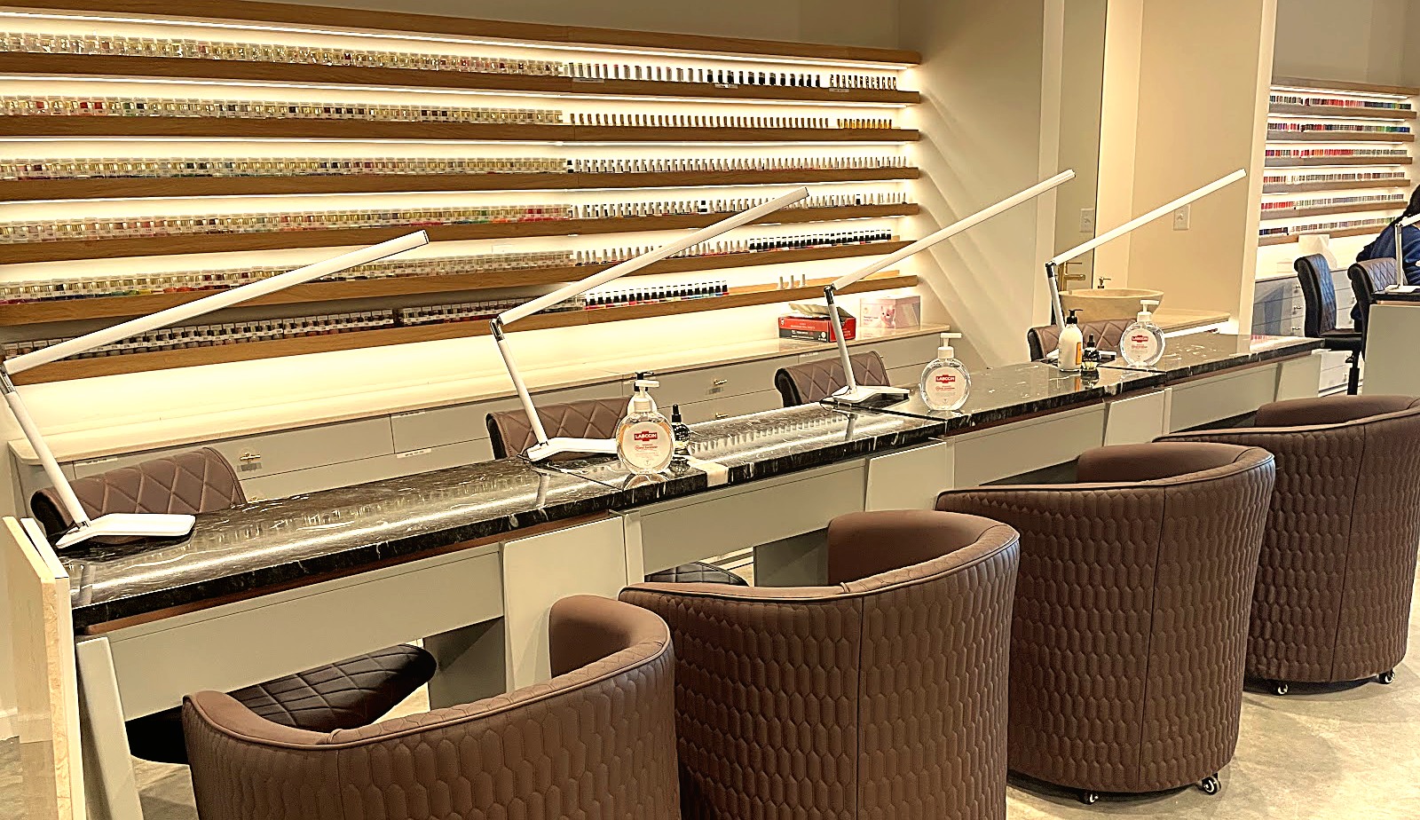 Manicure stations and the polish wall at VSL Nail Spa Lone Oak